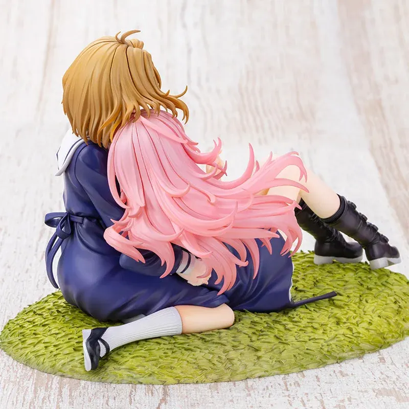 Back view of the Kotobukiya Shina Mimi figure, two schoolgirls in navy uniforms in a tender embrace on a grassy base with sculpted hair and boots.